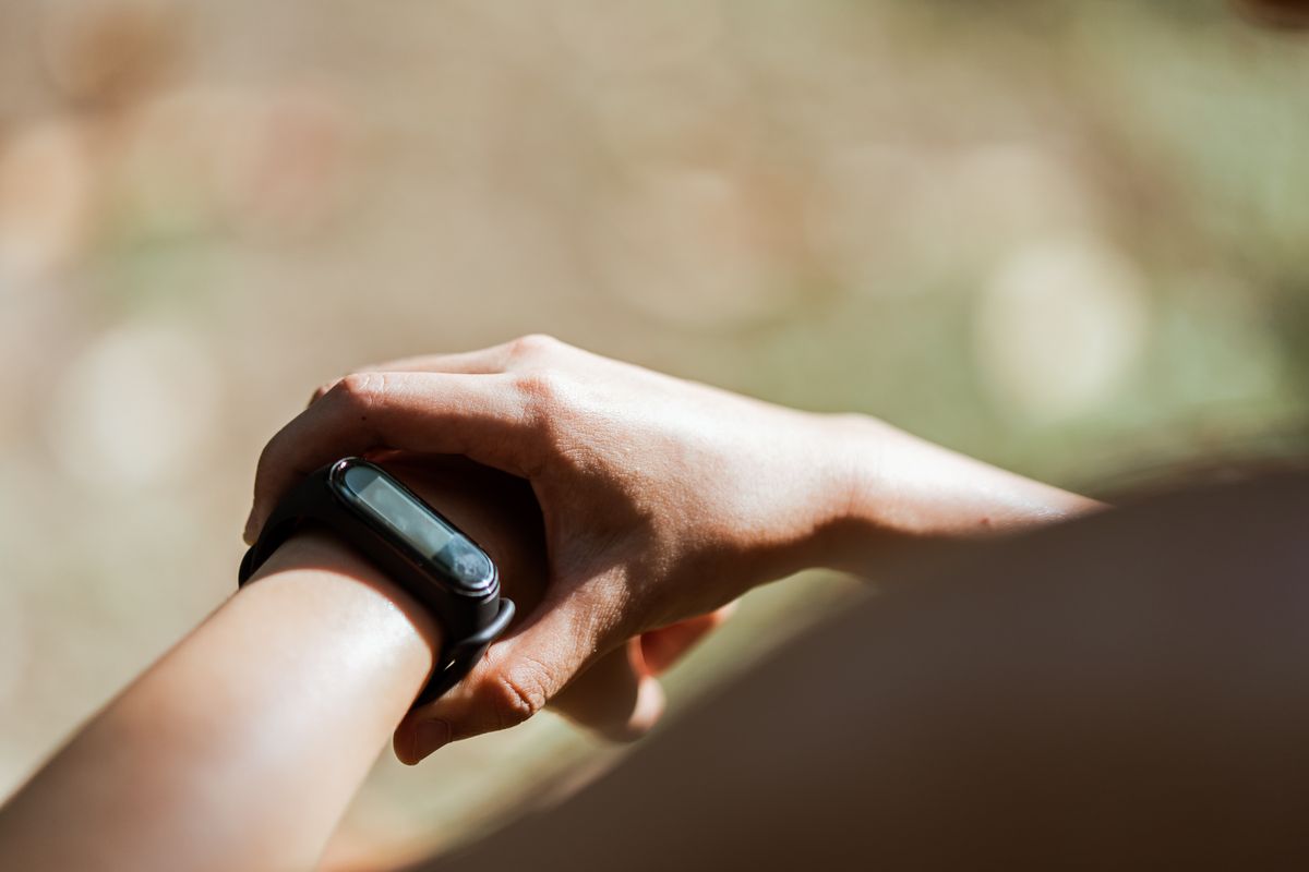 Person checking a fitness band outdoors in the sun