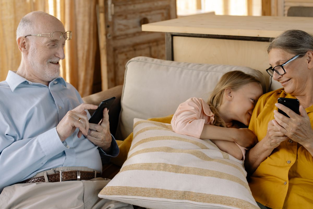 Grandparents using smartphones at home with their grandchild