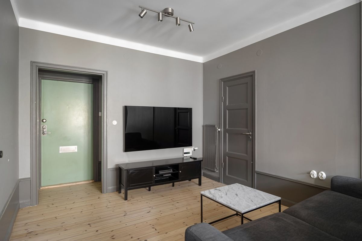 Sala gris con pantalla plana sobre un mueble bajo