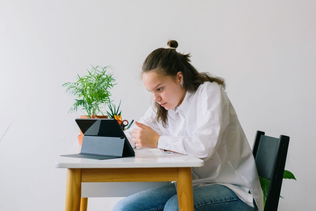 Tablet, Earbuds and Smartwatch for Study and Work Student studying at a desk with a tablet