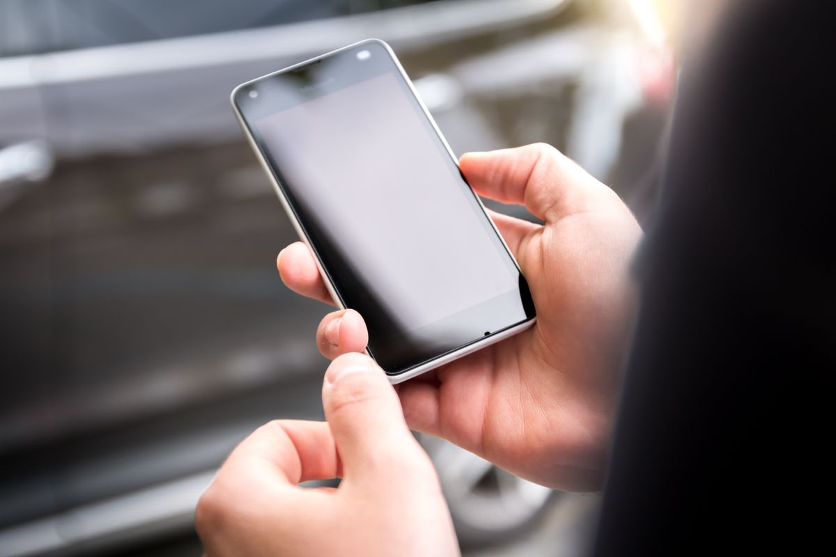 Two hands holding a smartphone with a blank screen